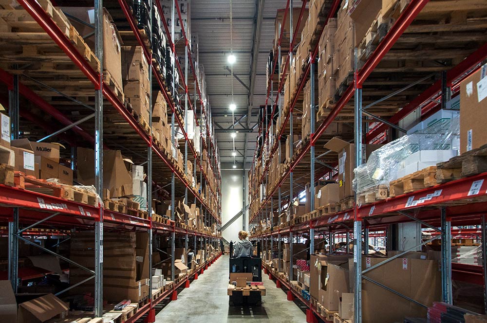 Truckförare på lager fyllt med lagerlådor